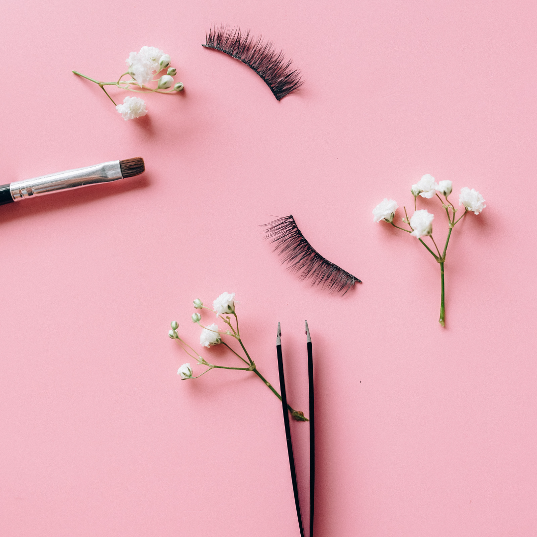 set of pink background with eyelashes, tweezers and flowers